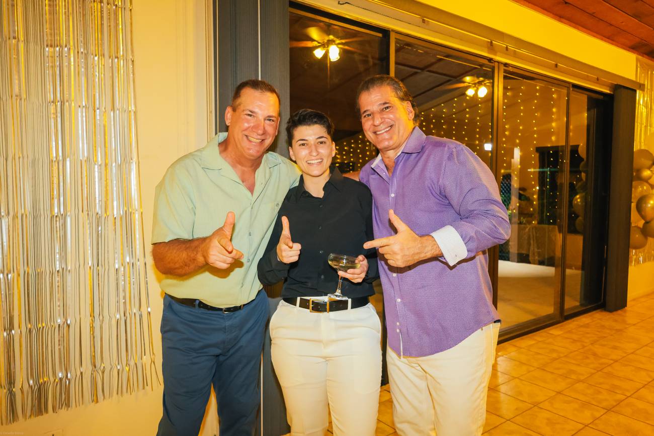 Two proud men flashing thumbs up with one of the brides-to-be at the celebration