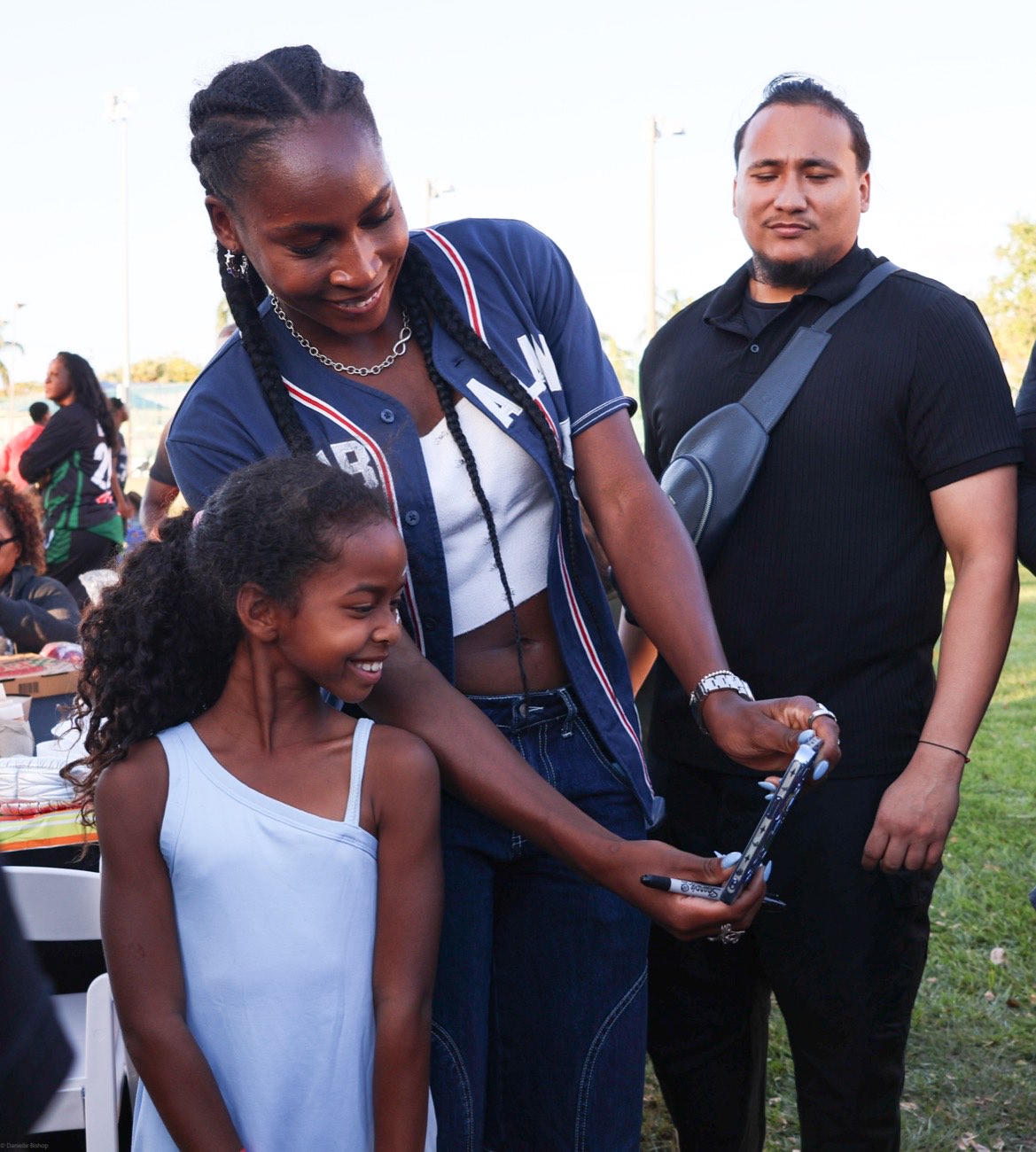 Coco Gauff leaning in for a selfie with a beaming young fan at her community celebration at Pompey Park