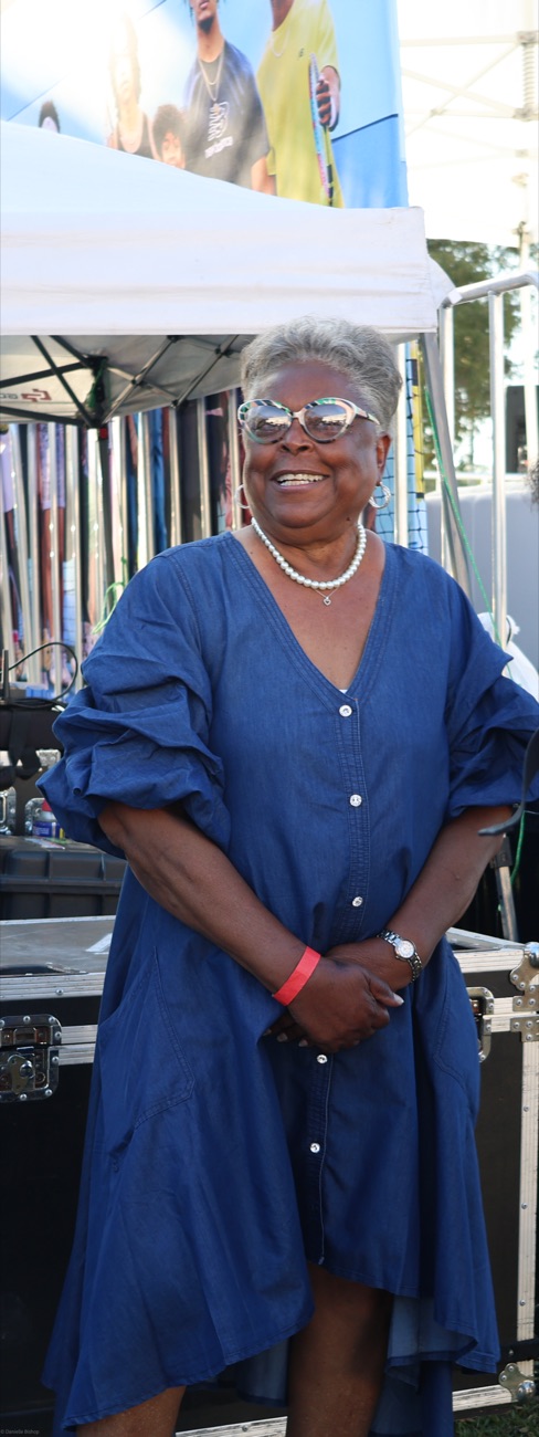 Yvonne Odom, Coco Gauff's grandmother, smiling in a blue denim dress at the celebration