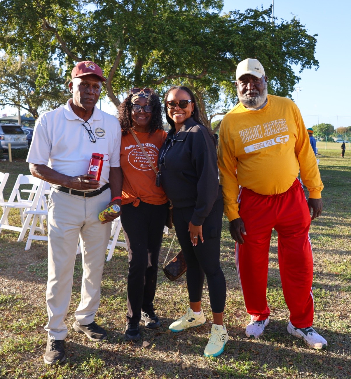 Four smiling community members together on the lawn at the Pompey Park celebration