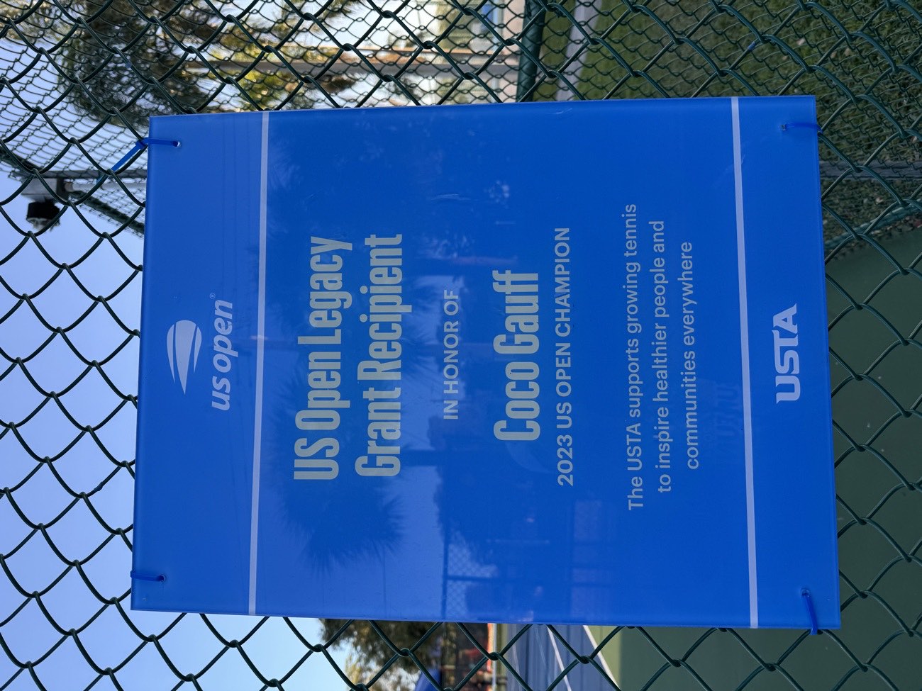 A US Open Legacy Grant plaque in honor of Coco Gauff, 2023 US Open champion, on the court fence at Pompey Park