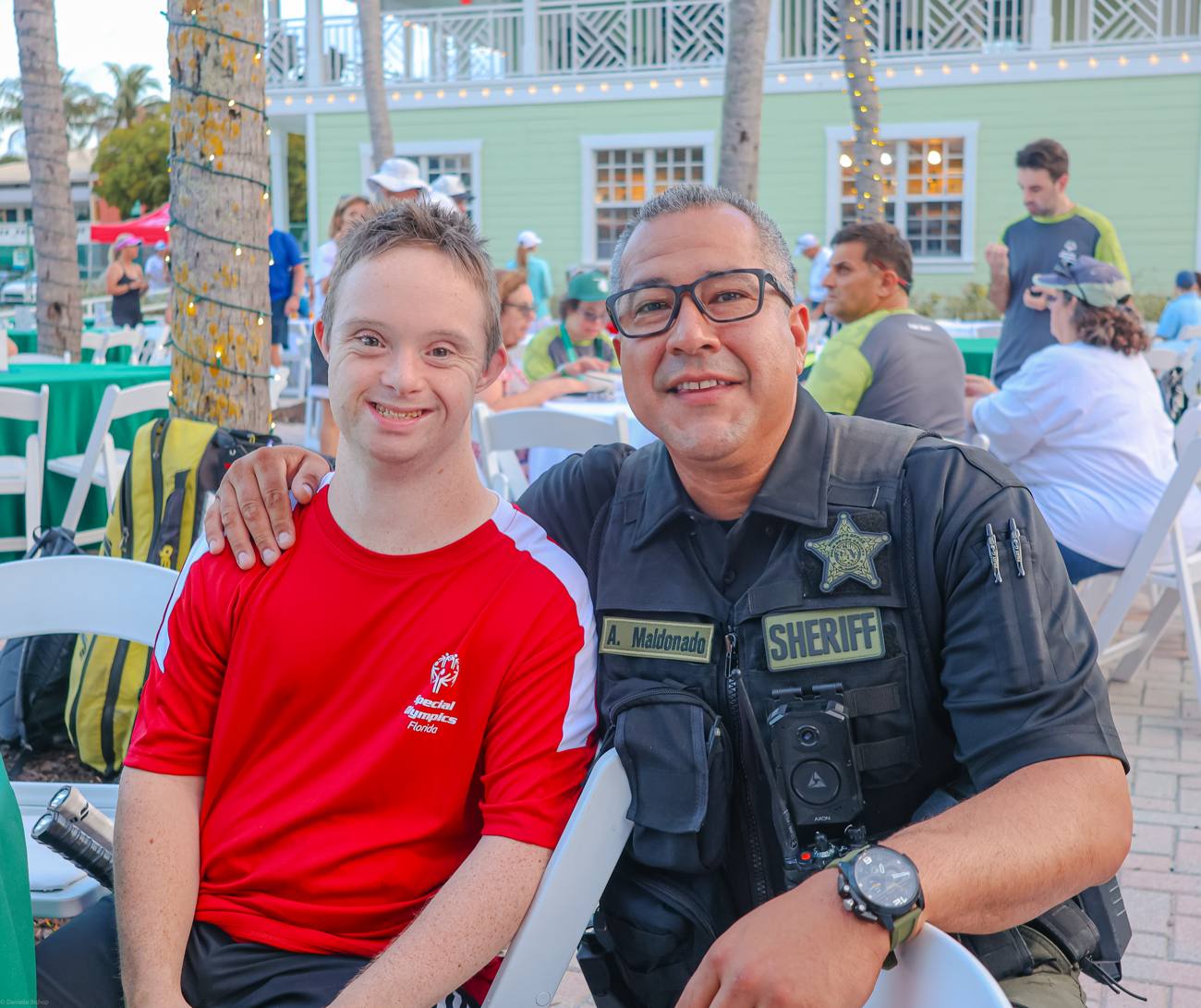 A Special Olympics athlete and a smiling sheriff's deputy side by side at the celebration