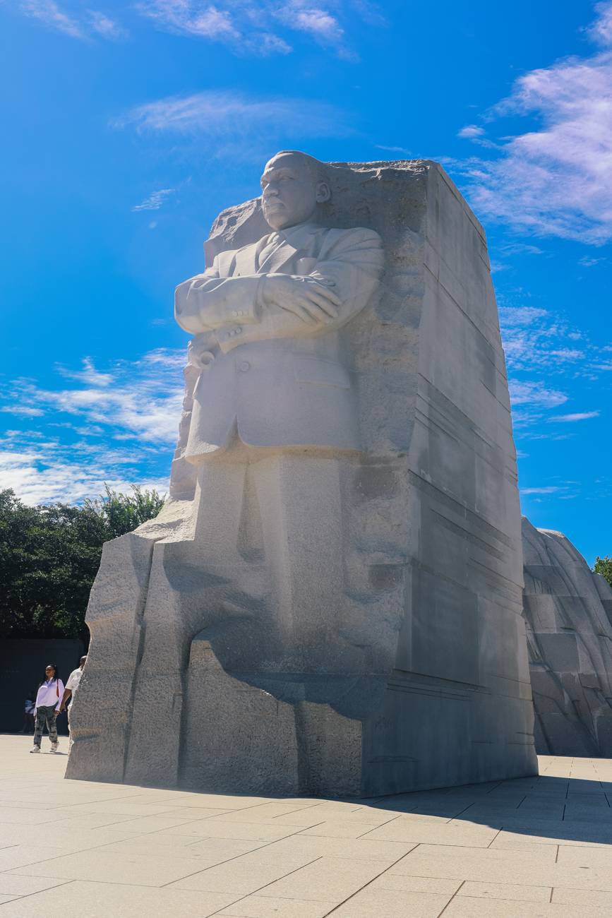 The Martin Luther King Jr. Memorial statue rising against a deep blue sky