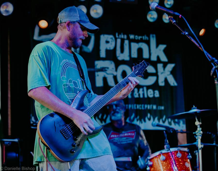 Guitarist of Goat Rope performing under the Lake Worth Punk Rock Festival banner