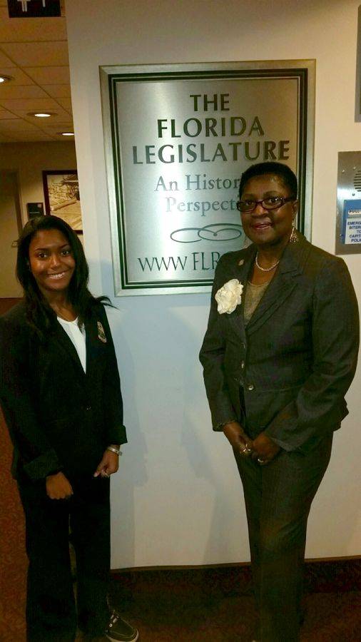Young Danielle with Representative Hazelle Rogers beside The Florida Legislature sign