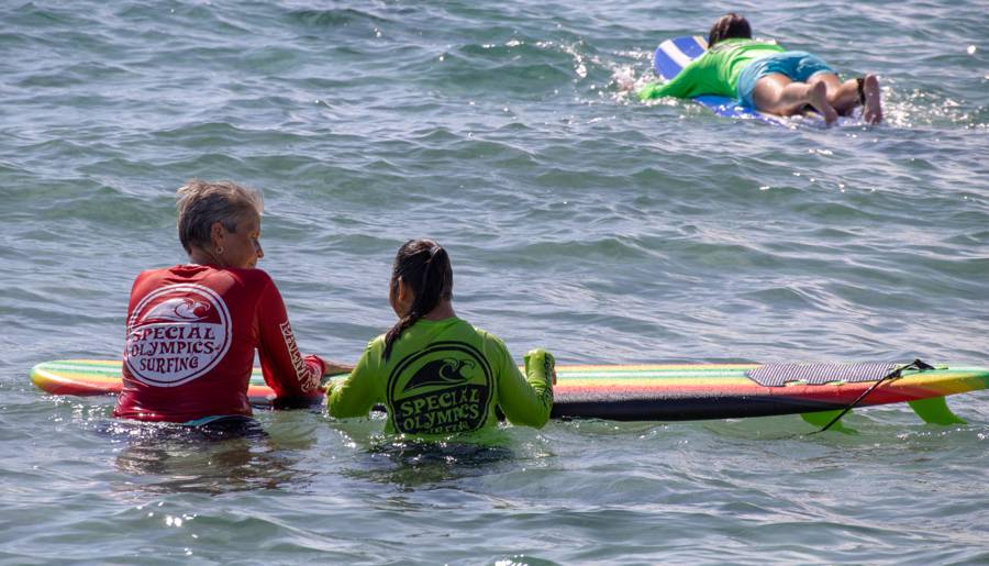 Surf instructors guiding young athletes on boards in the ocean