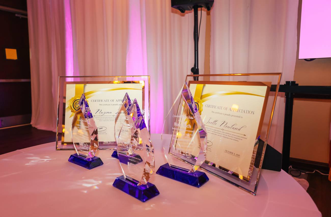 Crystal awards and framed certificates of appreciation arranged on a table before the ceremony