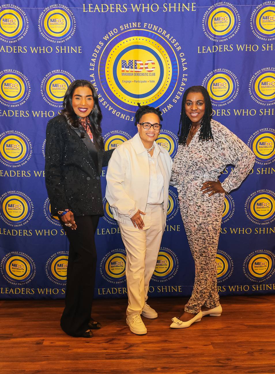 State Senator Barbara Sharief, MDC President Donna Hinds, and a guest smiling on the Leaders Who Shine backdrop