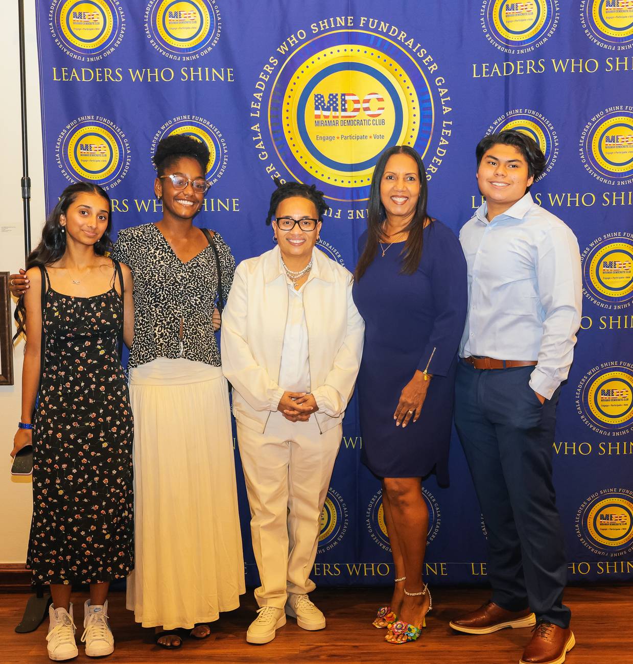 MDC President Donna Hinds with four young guests on the Leaders Who Shine backdrop