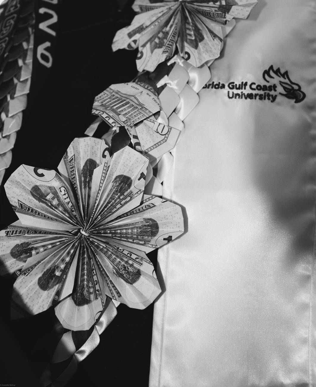 A close-up of a graduation cap flower and tassel in black and white