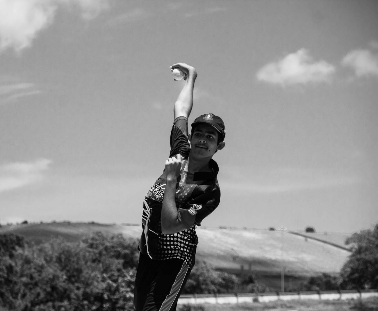 A dancer mid-leap outdoors, in black and white