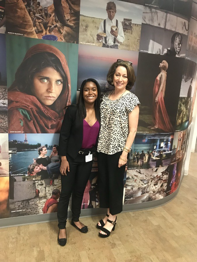 Danielle with former National Geographic Editor in Chief Susan Goldberg in front of the photo wall, the Afghan Girl portrait behind them