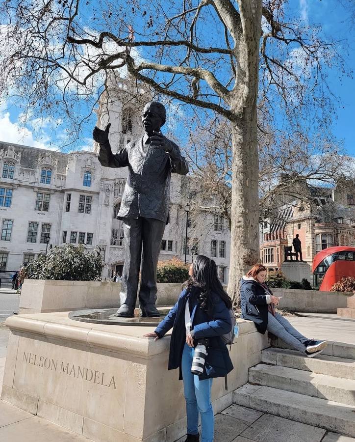 Danielle with her camera looking up at the Nelson Mandela statue in Parliament Square, London