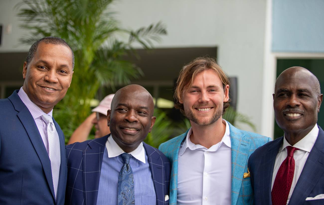 Four smiling guests in suits together at the Benjamin L. Crump College of Law celebration
